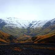 Snow-capped mountain range in Akranes, showcasing the beauty of nature's peaks against a clear blue sky