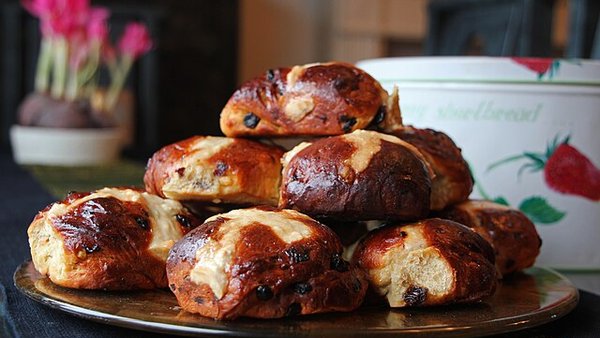 A plate stacked with freshly baked hot cross buns, made according to the recipe